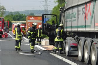 Feuerwehrleute inspizieren den verkohlten Lkw: Der Lastwagen ist auf der A45 in Brand geraten.