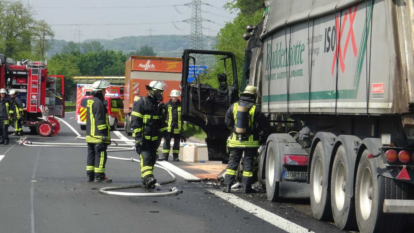 Feuerwehrleute inspizieren den verkohlten Lkw: Der Lastwagen ist auf der A45 in Brand geraten.