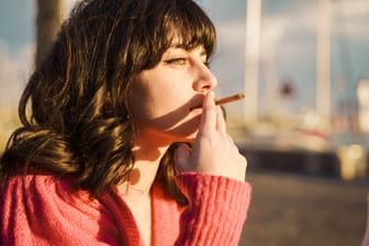 Junge Frau raucht genüsslich eine Zigarette