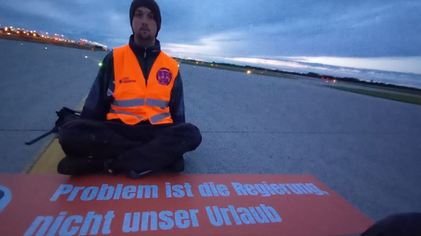 Ein Klimaaktivist auf der Start- und Landebahn des Franz-Josef-Strauß Flughafens in München: Am Samstag blockierten Klimaaktivisten die Landebahn.