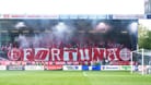 Die Fans von Fortuna Düsseldorf beim Auswärtsspiel in Kiel: Nach der Pause zeigten die Anhänger das Banner mit einer Botschaft für Georg Koch.