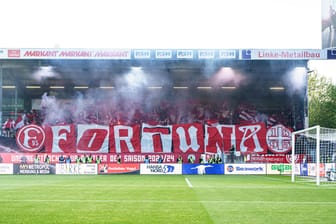 Die Fans von Fortuna Düsseldorf beim Auswärtsspiel in Kiel: Nach der Pause zeigten die Anhänger das Banner mit einer Botschaft für Georg Koch.