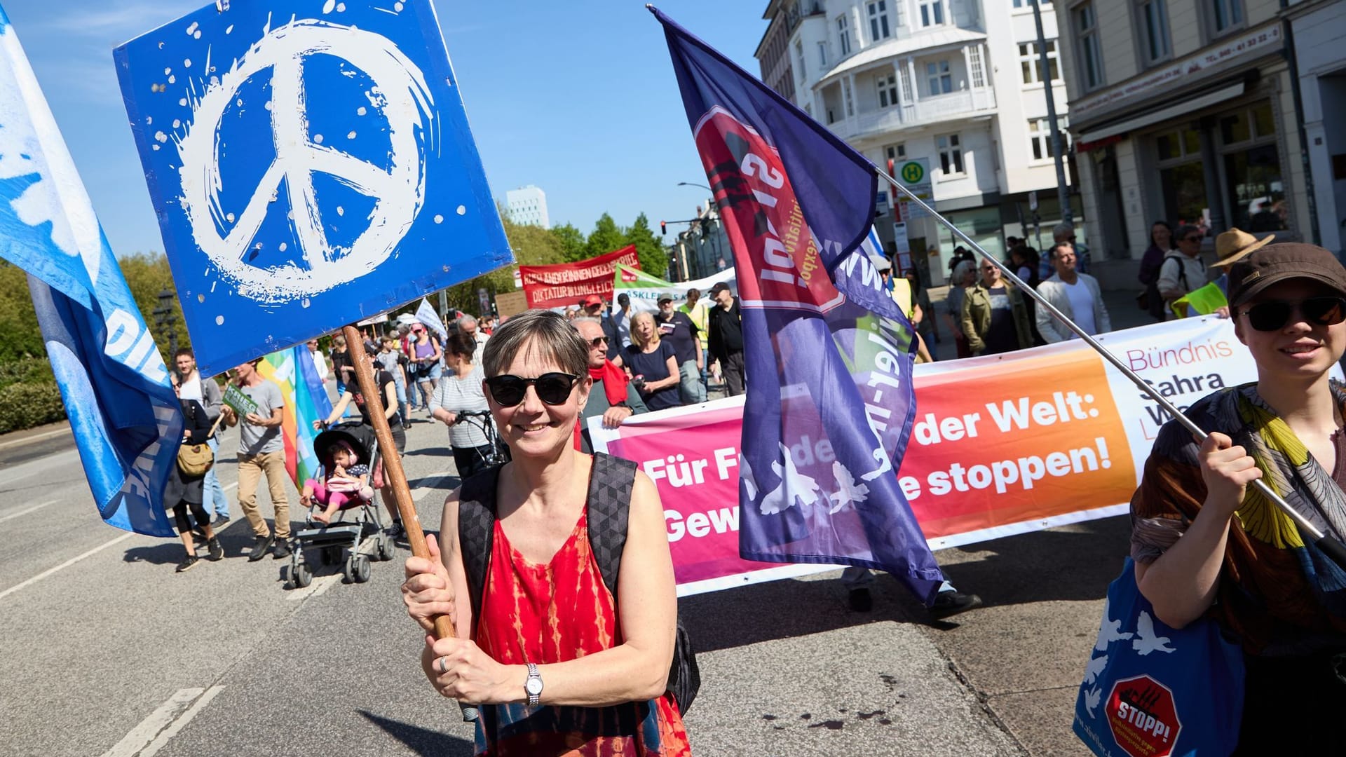 Eine Demonstrantin hält ein Transparent mit dem Peace-Symbol hoch: Der DGB rechnete in Hamburg mit rund 3000 Teilnehmenden. Eine Demonstrantin hält ein Transparent mit dem Peace-Symbol hoch: Der DGB rechnete in Hamburg mit rund 3000 Teilnehmenden.