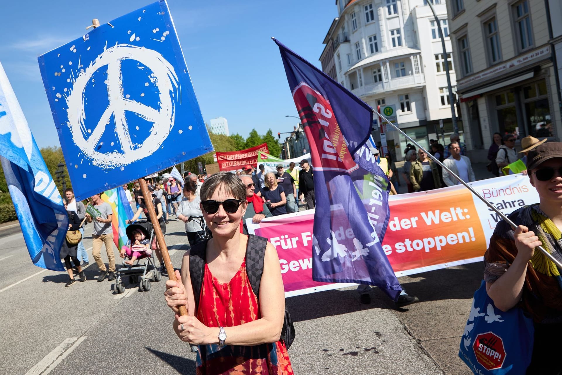 Eine Demonstrantin hält ein Transparent mit dem Peace-Symbol hoch: Der DGB rechnete in Hamburg mit rund 3000 Teilnehmenden.