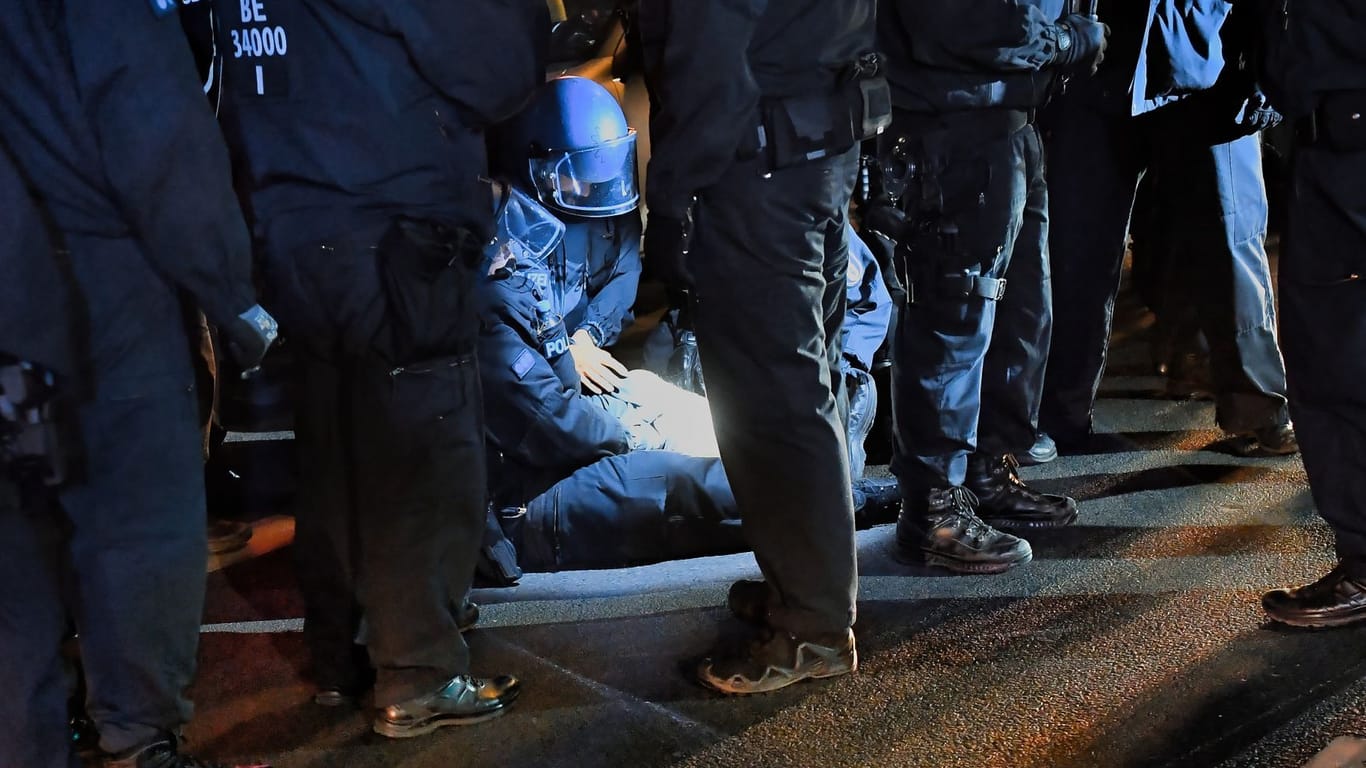 Polizeibeamte kümmern sich am Abend um einen verletzten Kollegen auf der Sonnenallee