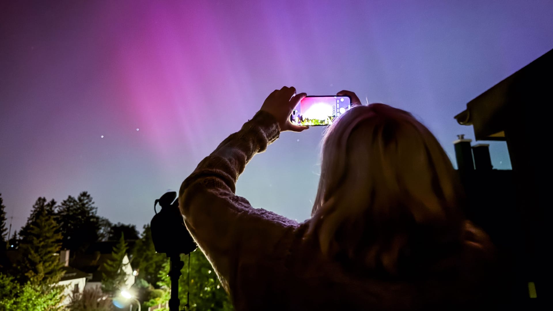 Eine Frau fotografiert die Polarlichter über München-Riem: Mit etwas Glück sind diese am Samstag noch einmal zu sehen.