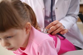 Little girl at doctor lung area examined with stethoscope