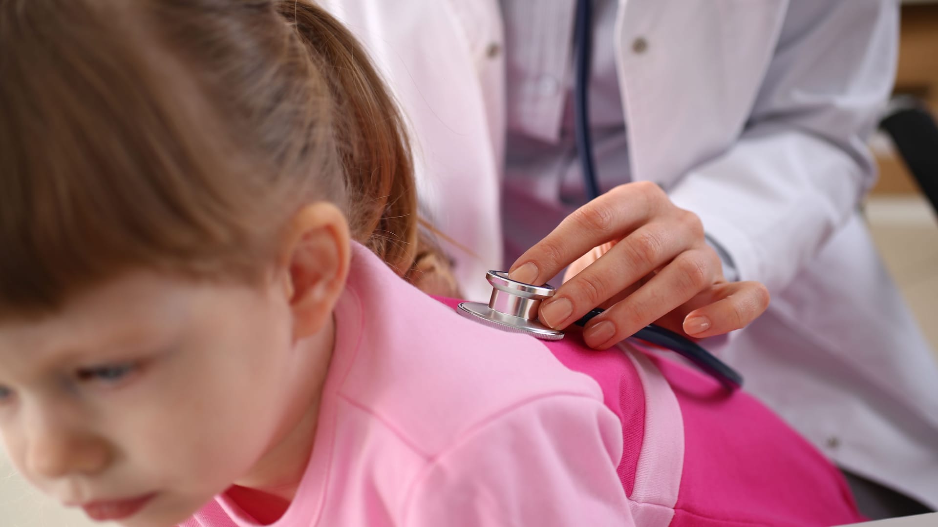 Little girl at doctor lung area examined with stethoscope Little girl at doctor lung area examined with stethoscope