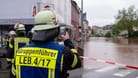 Ein Feuerwehrmann fotografiert das Hochwasser der Theel in der Innenstadt von Lebach