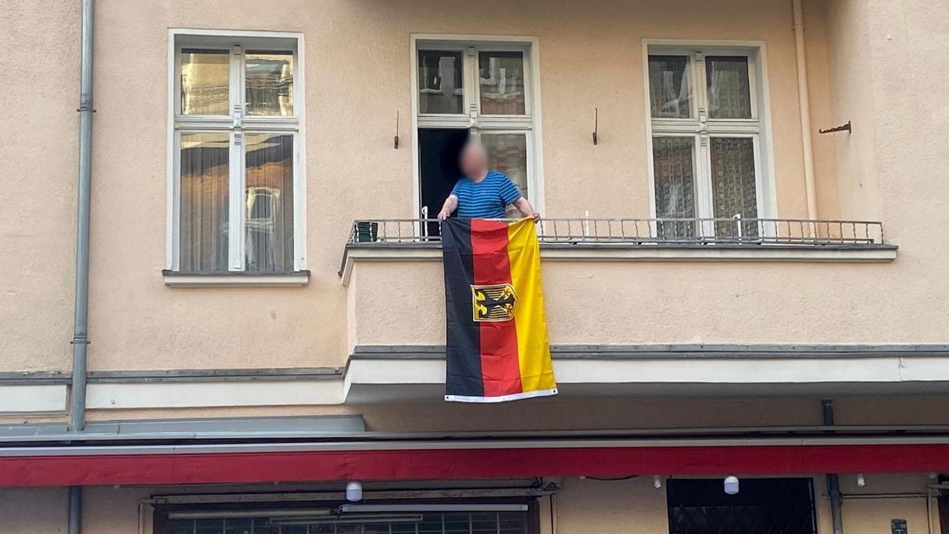 Mann hält Deutschlandflagge: Später flog ein Böller auf seinen Balkon.