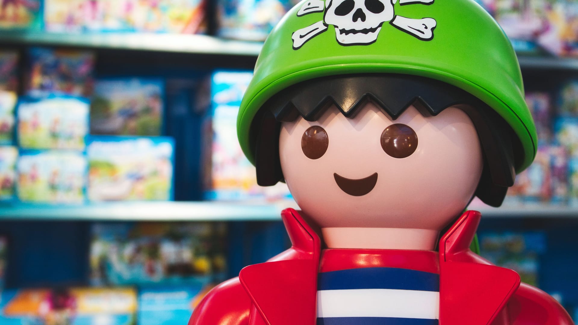Giant Playmobil pirate figure in a toy shop with shelves of Playmobil box sets
