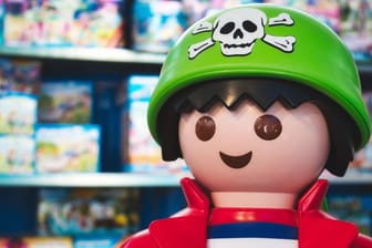 Giant Playmobil pirate figure in a toy shop with shelves of Playmobil box sets