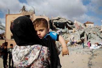 Menschen stehen an einem Ort in Rafah nach einem Luftangriff: In die Stadt im Süden Gazas sind Hunderttausende geflohen. (Quelle: Hatem Khaled/reuters)
