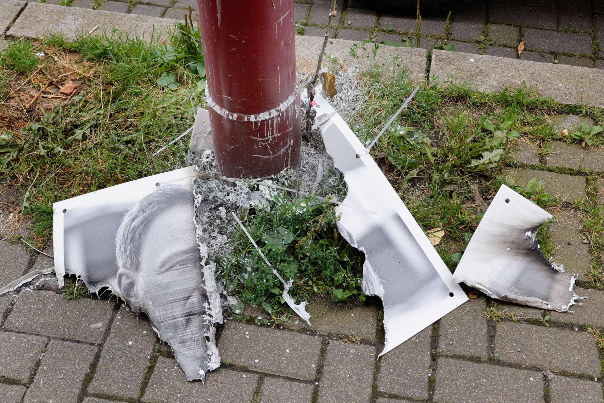 Ein verbranntes Wahlplakat liegt auf dem Boden (Archivbild): Die Tat soll von drei Männern begangen worden sein.