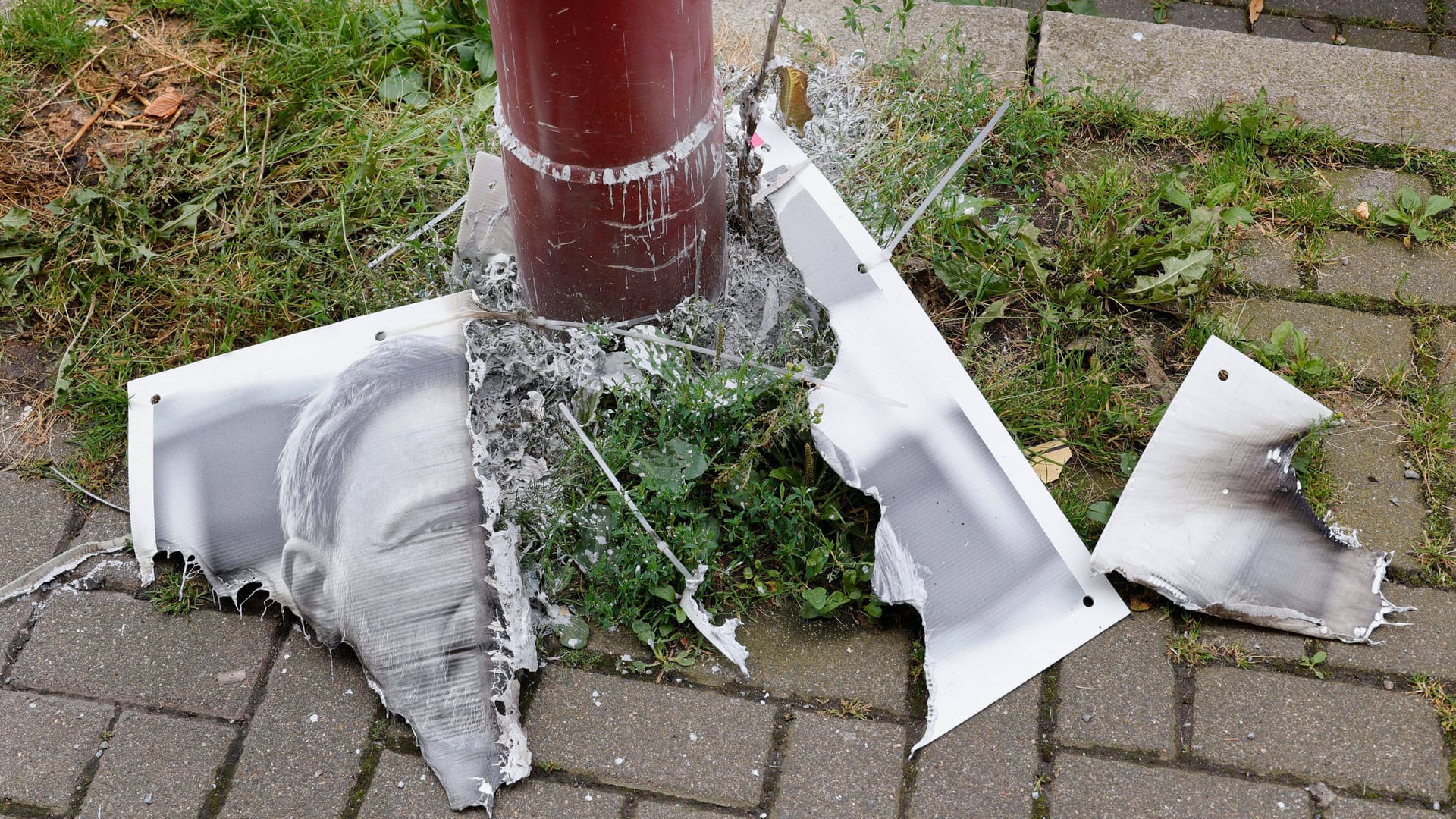 Ein verbranntes Wahlplakat liegt auf dem Boden (Archivbild): Die Tat soll von drei Männern begangen worden sein.