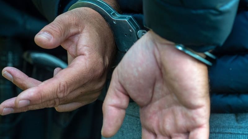 Ein Mann trägt Handschellen Ein Mann trägt Handschellen