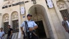 Betlehem: Ein Polizist und mehrere Einheimische stehen vor einer Filiale der Bank of Palestine.