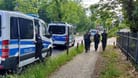 30.05.2024, Brandenburg, Potsdam: Polizisten gehen am abgesperrten Tatort in der Potsdamer Geschwister-Scholl-Straße entlang.