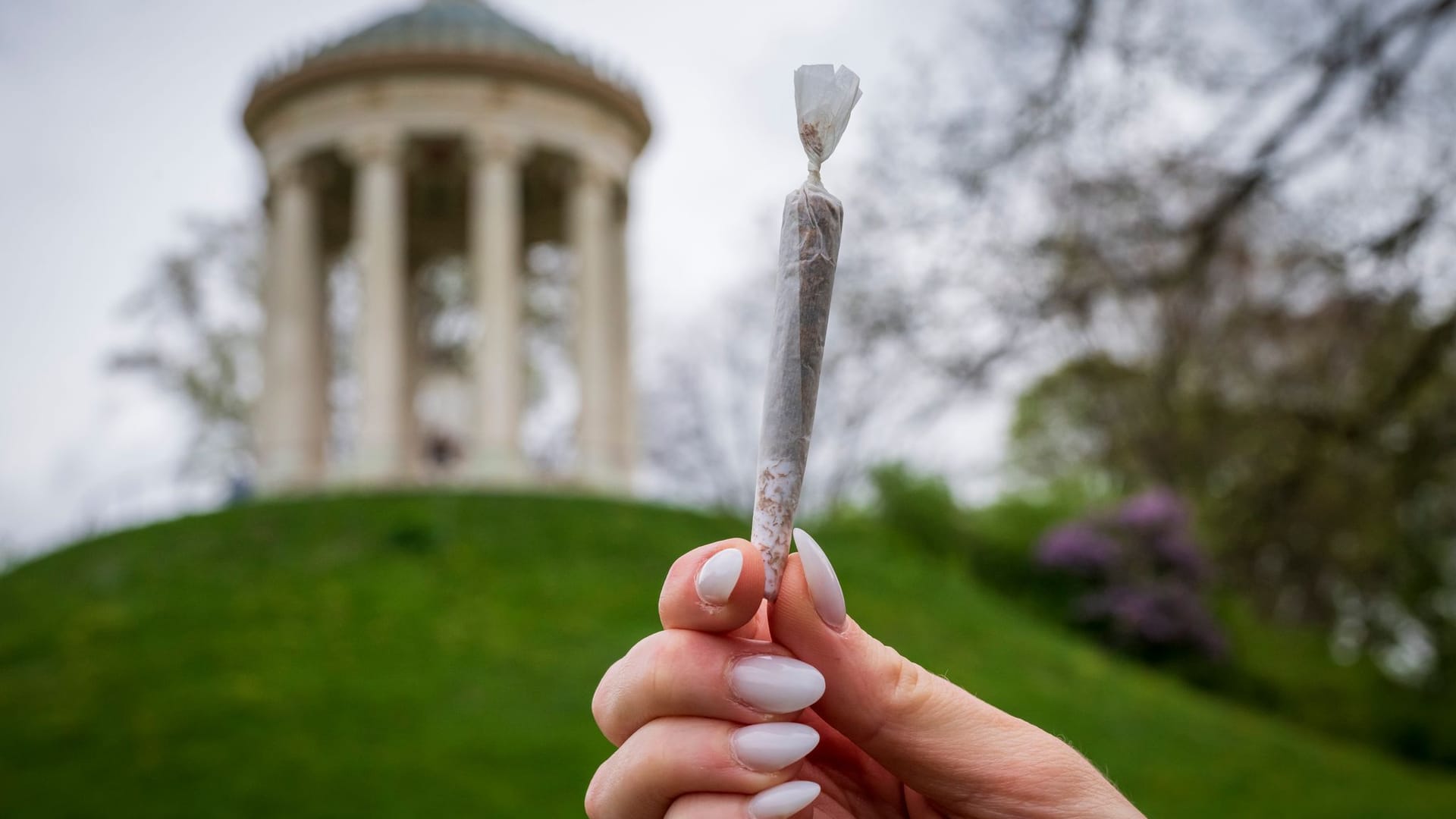 Eine Frau hält im Englischen Garten einen Joint in der Hand: Das Kiffverbot war erst vor kurzem beschlossen und angekündigt worden.