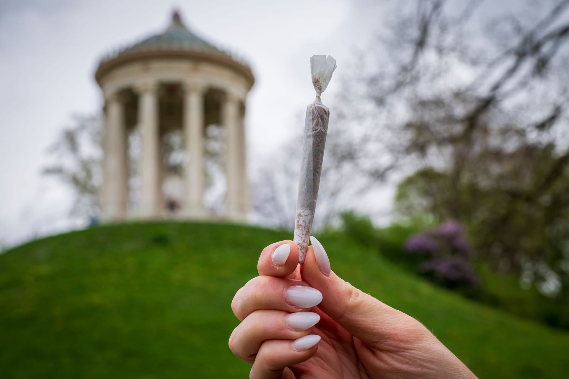 Eine Frau hält im Englischen Garten einen Joint in der Hand: Das Kiffverbot war erst vor kurzem beschlossen und angekündigt worden.