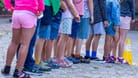 Kinder stehen auf dem Schulhof einer Grundschule