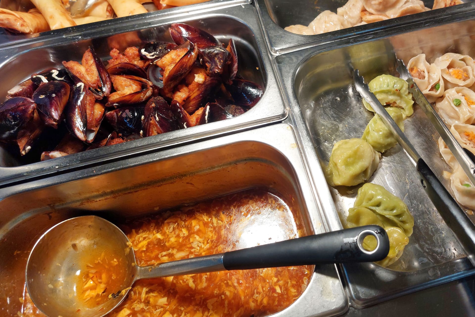 dishes in a well-stocked Chinese restaurant on stainless steel trays