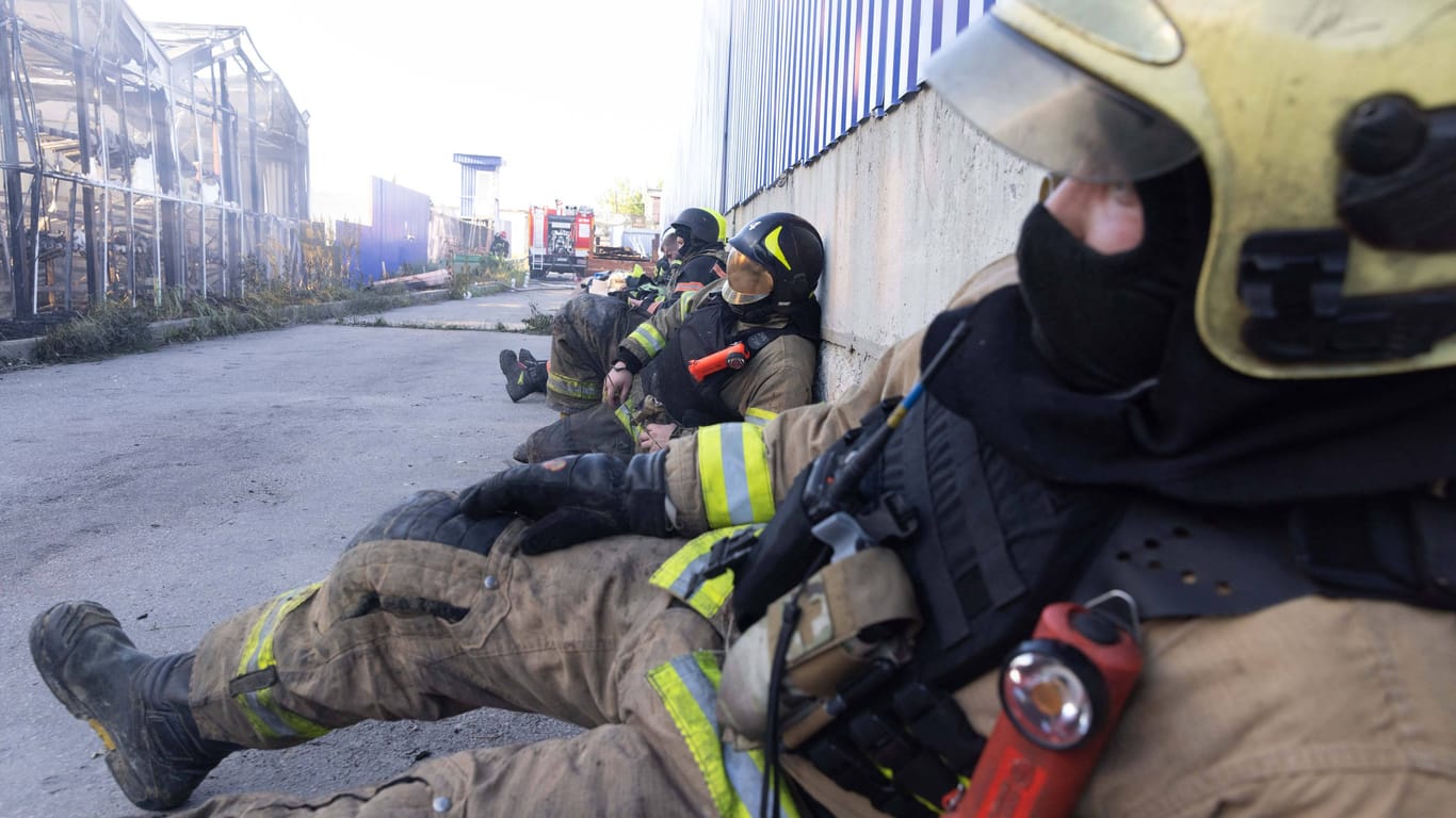 Erschöpft: Ukrainische Feuerwehrmänner am Ort des russischen Angriffs auf einen Baumarkt.