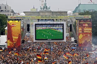 Fans schauen sich ein Fußballspiel am Brandenburger Tor an (Symbolbild): Zur EM 2024 werden in Berlin in den Fanbereichen 50.000 bis 100.000 Zuschauer erwartet.
