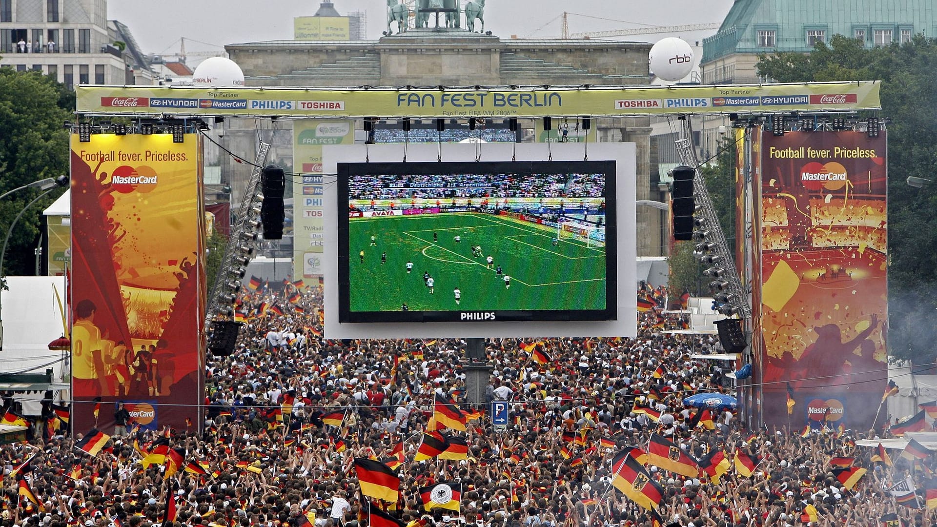 Fans schauen sich ein Fußballspiel am Brandenburger Tor an (Symbolbild): Zur EM 2024 werden in Berlin in den Fanbereichen 50.000 bis 100.000 Zuschauer erwartet.