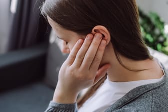 Frau mit Ohrenschmerzen: Welchen Verlauf eine Gehörgangsentzündung nimmt, hängt auch davon ab, wie frühzeitig sie behandelt wird.