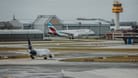 Ein Flugzeug landet am Hamburger Flughafen, während ein anderes auf die Starterlaubnis wartet. (Archivbild)