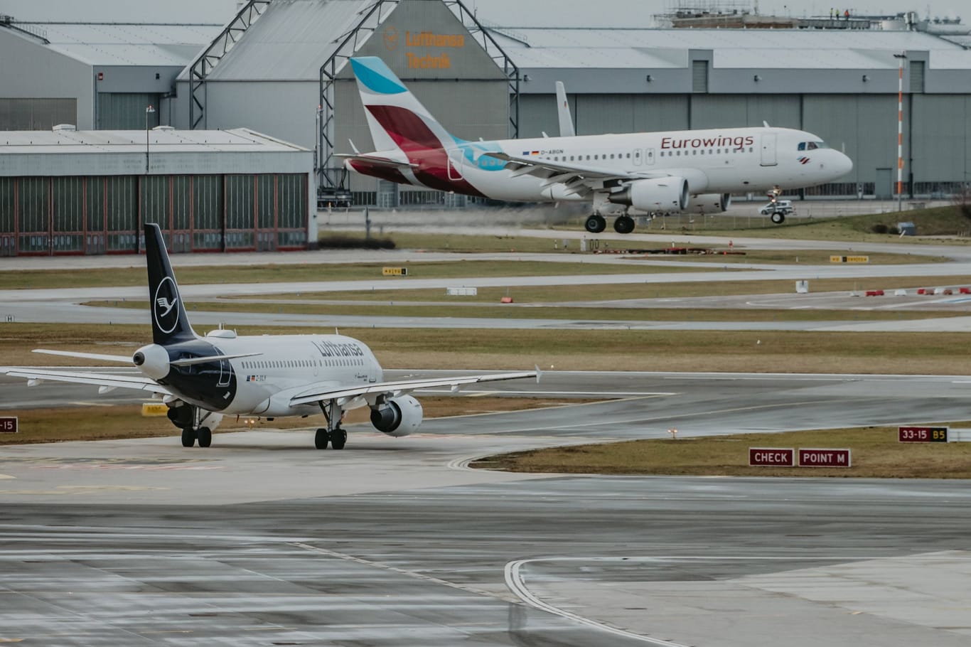 Ein Flugzeug landet am Hamburger Flughafen, während ein anderes auf die Starterlaubnis wartet. (Archivbild)