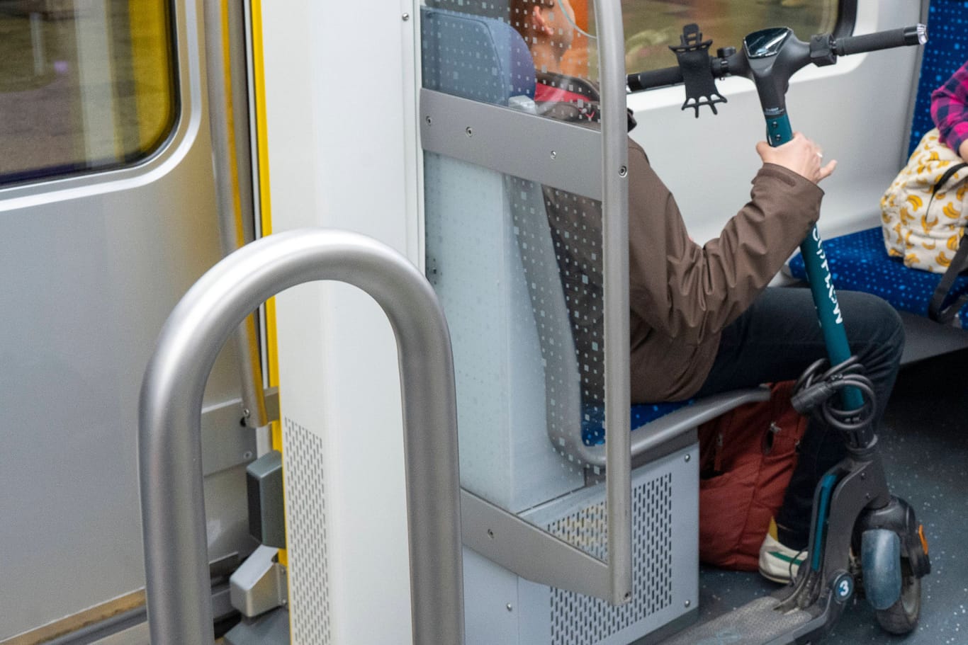 Ein Mensch sitzt mit einem E-Scooter in einer Bahn (Symbolbild): Im Verkehrsverbund Bremen/Niedersachsen ist das ab Juni tabu.