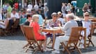 Menschen sitzen im Außenbereich eines Restaurants (Archivbild): FDP, CDU und SPD wollen Vorgaben für die Außengastronomie lockern.