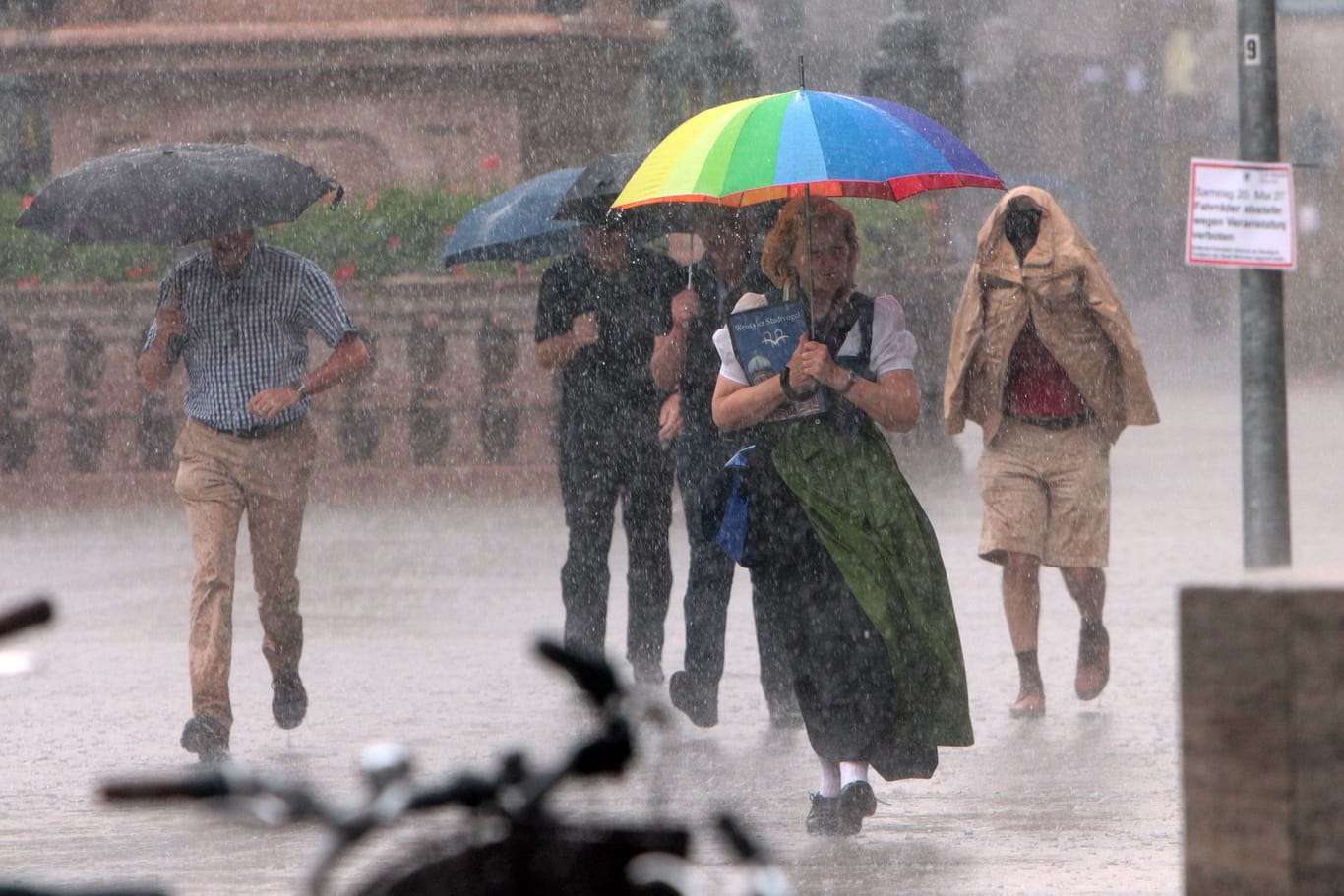 Menschen laufen im strömenden Regen über den Marienplatz (Archivbild): Ab dem frühen Nachmittag soll das Wetter in München umschlagen.