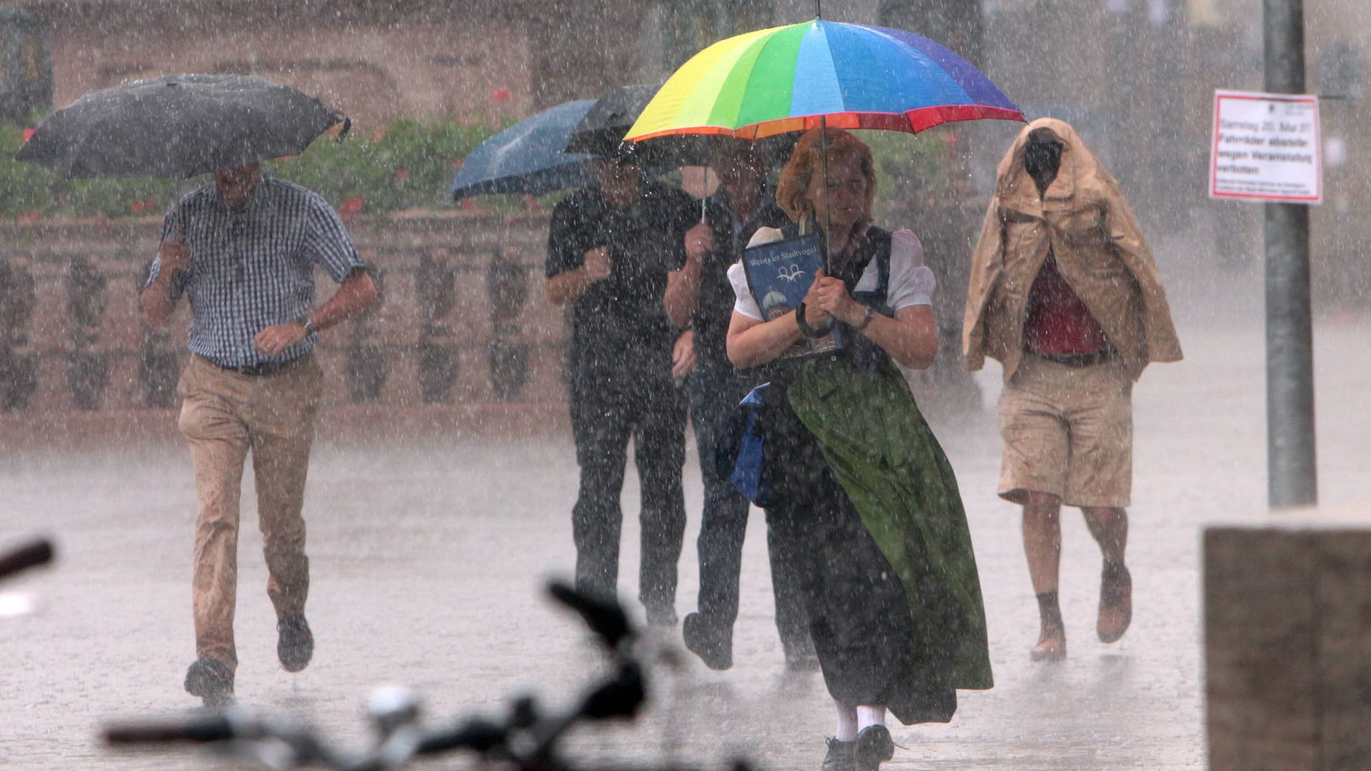 Menschen laufen im strömenden Regen über den Marienplatz (Archivbild): Ab dem frühen Nachmittag soll das Wetter in München umschlagen.