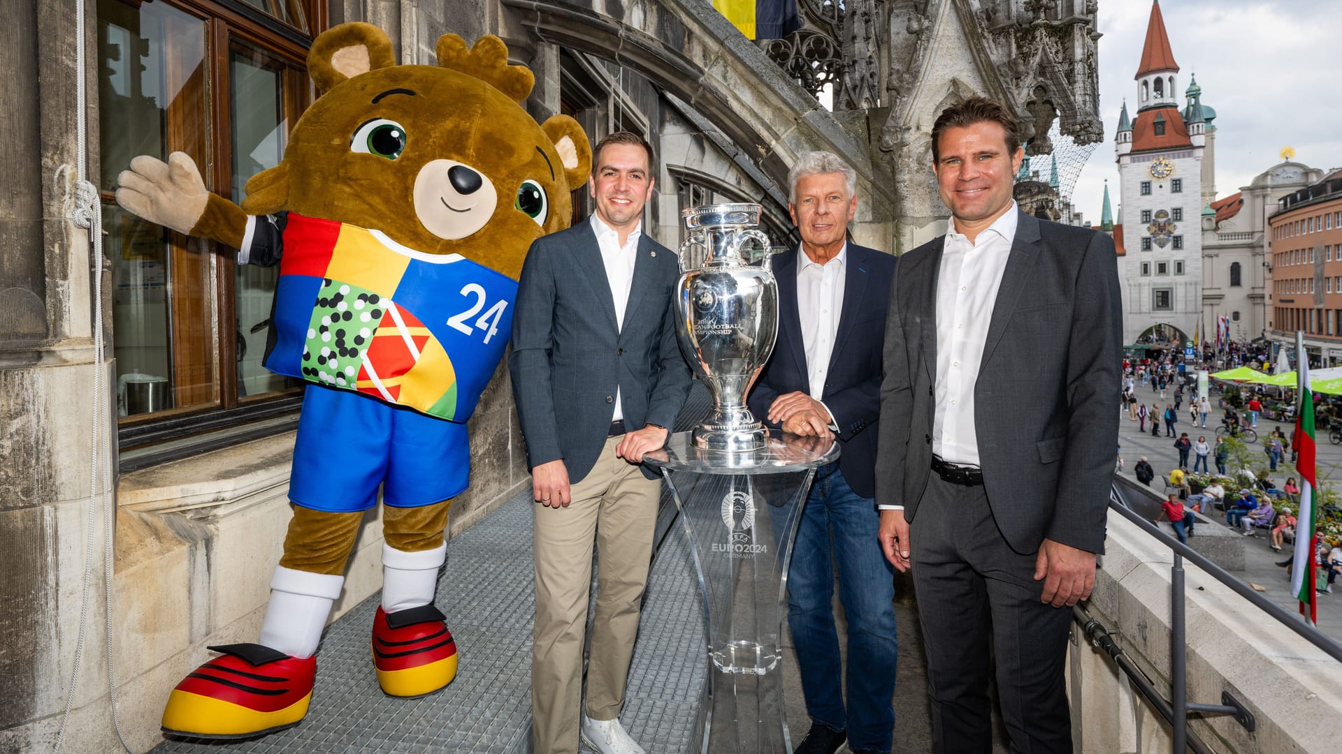 Posieren auf dem Rathausbalkon mit der begehrten Trophäe: (v.l.) Maskottchen Albärt, Turnierdirektor Phillipp Lahm, OB Dieter Reiter und Host-City-Botschafter Dr. Felix Brych.