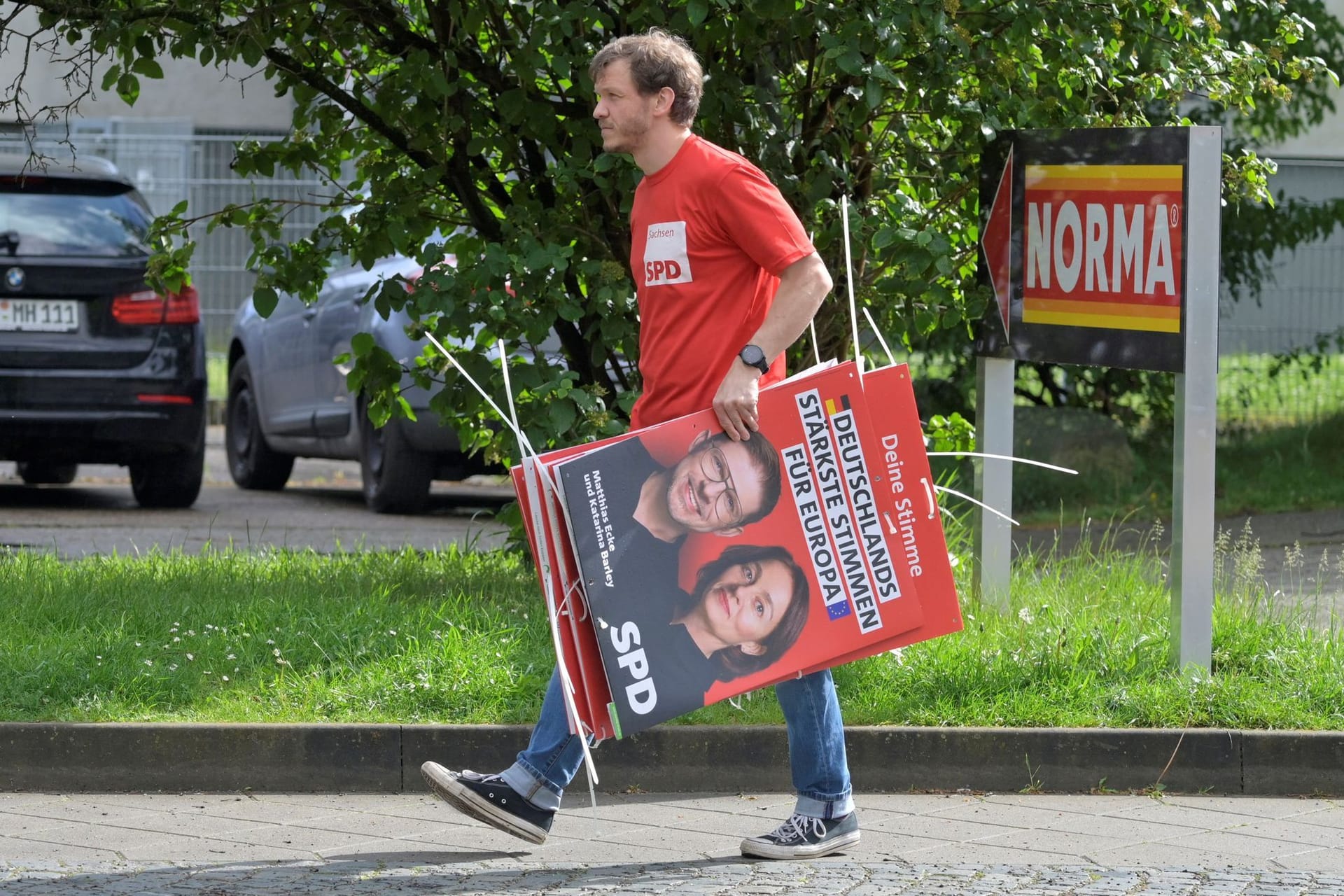 Ein Wahlkampfhelfer der SPD trägt ein Plakat mit Politiker Matthias Ecke: Ecke wurde Opfer eines brutalen Angriffs.