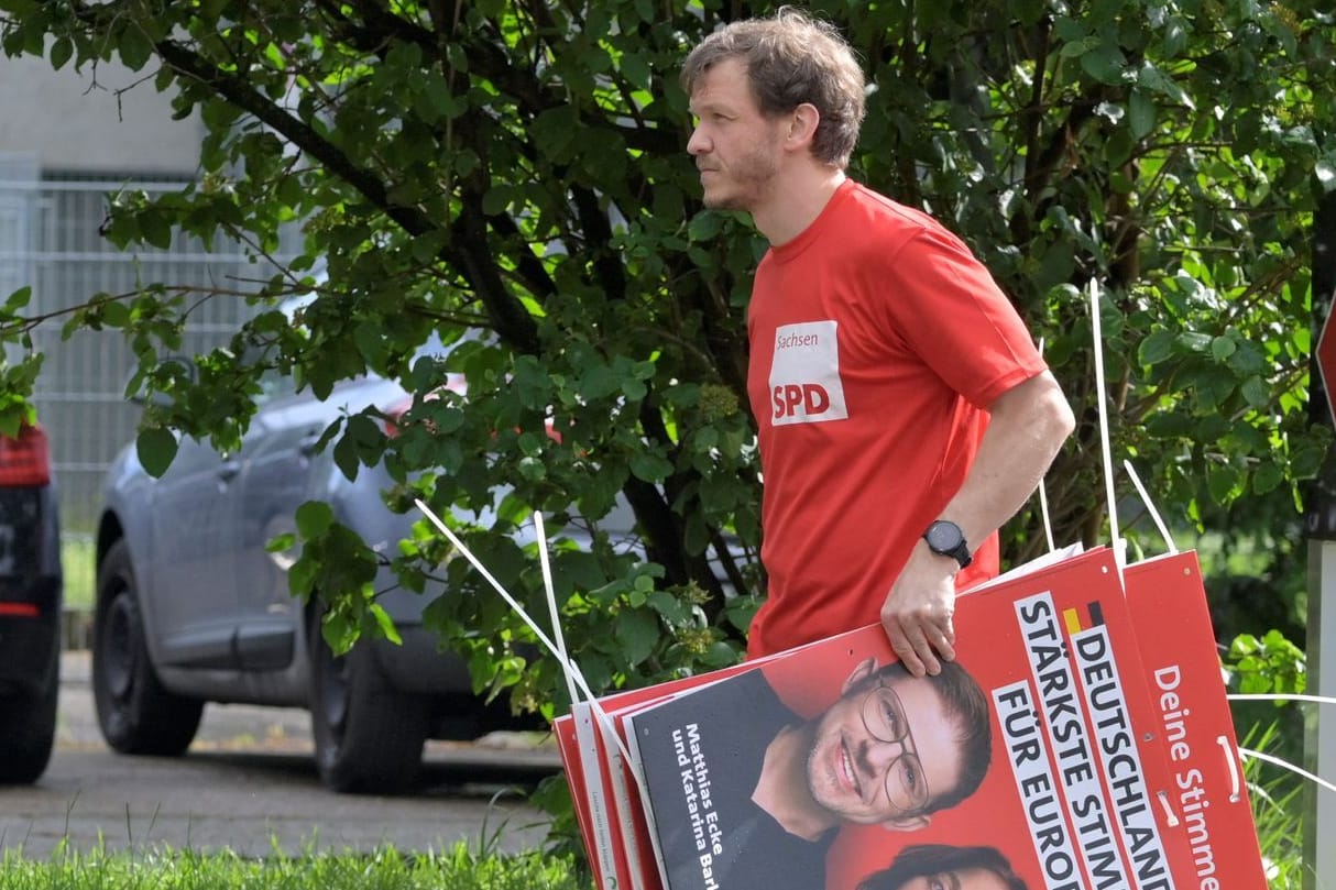 Ein Wahlkampfhelfer der SPD trägt ein Plakat mit Politiker Matthias Ecke: Ecke wurde Opfer eines brutalen Angriffs.