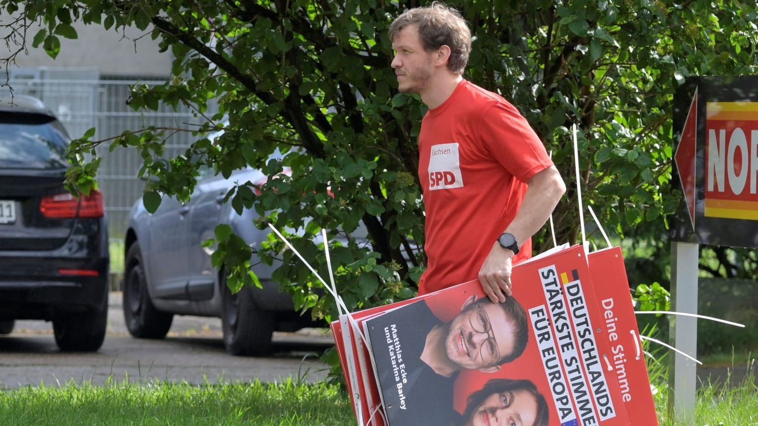 Ein Wahlkampfhelfer der SPD trägt ein Plakat mit Politiker Matthias Ecke: Ecke wurde Opfer eines brutalen Angriffs.