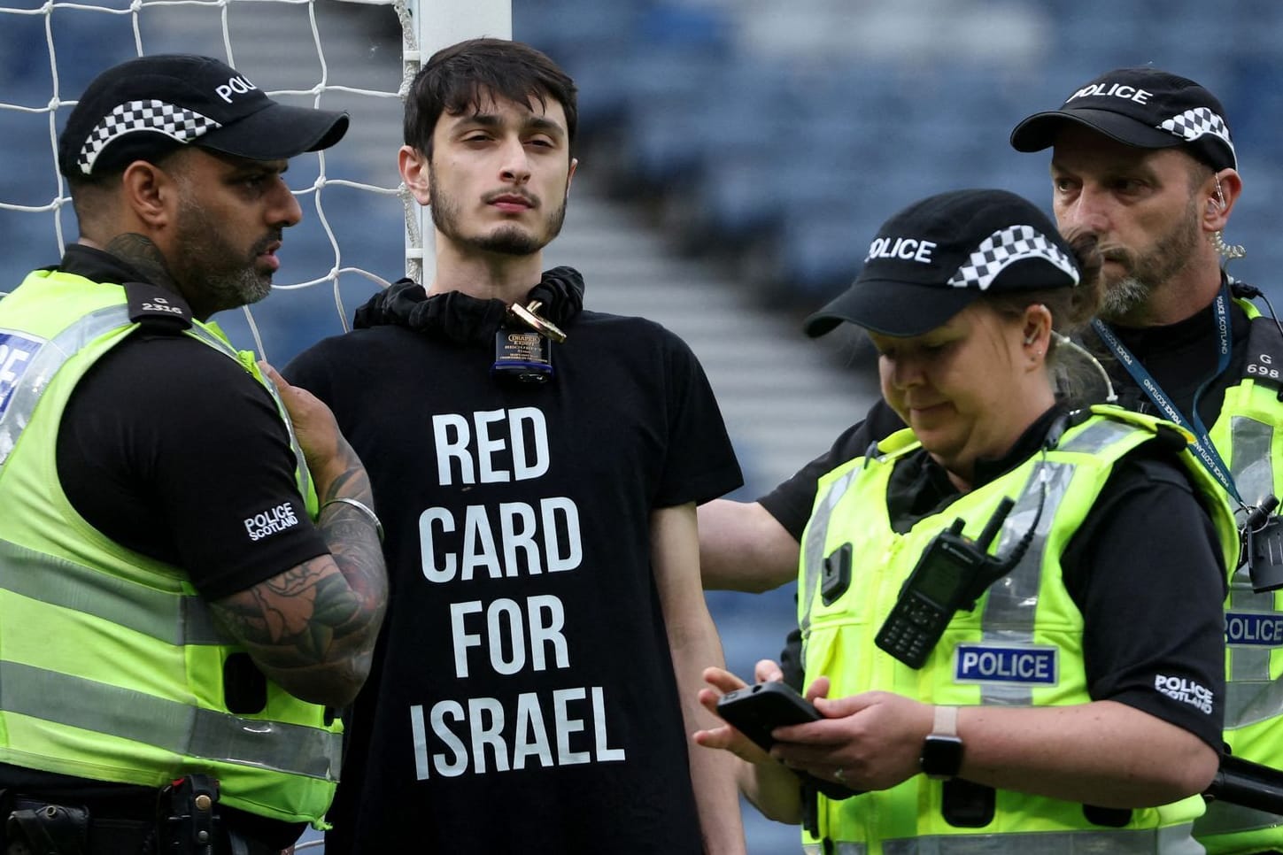 Protest: Ein Demonstrant hat sich an einen Pfosten im Hampden Park gekettet, Einsatzkräfte versuchen, ihn zu befreien.