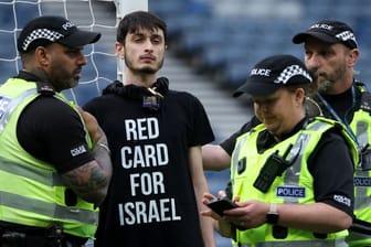 Protest: Ein Demonstrant hat sich an einen Pfosten im Hampden Park gekettet, Einsatzkräfte versuchen, ihn zu befreien.