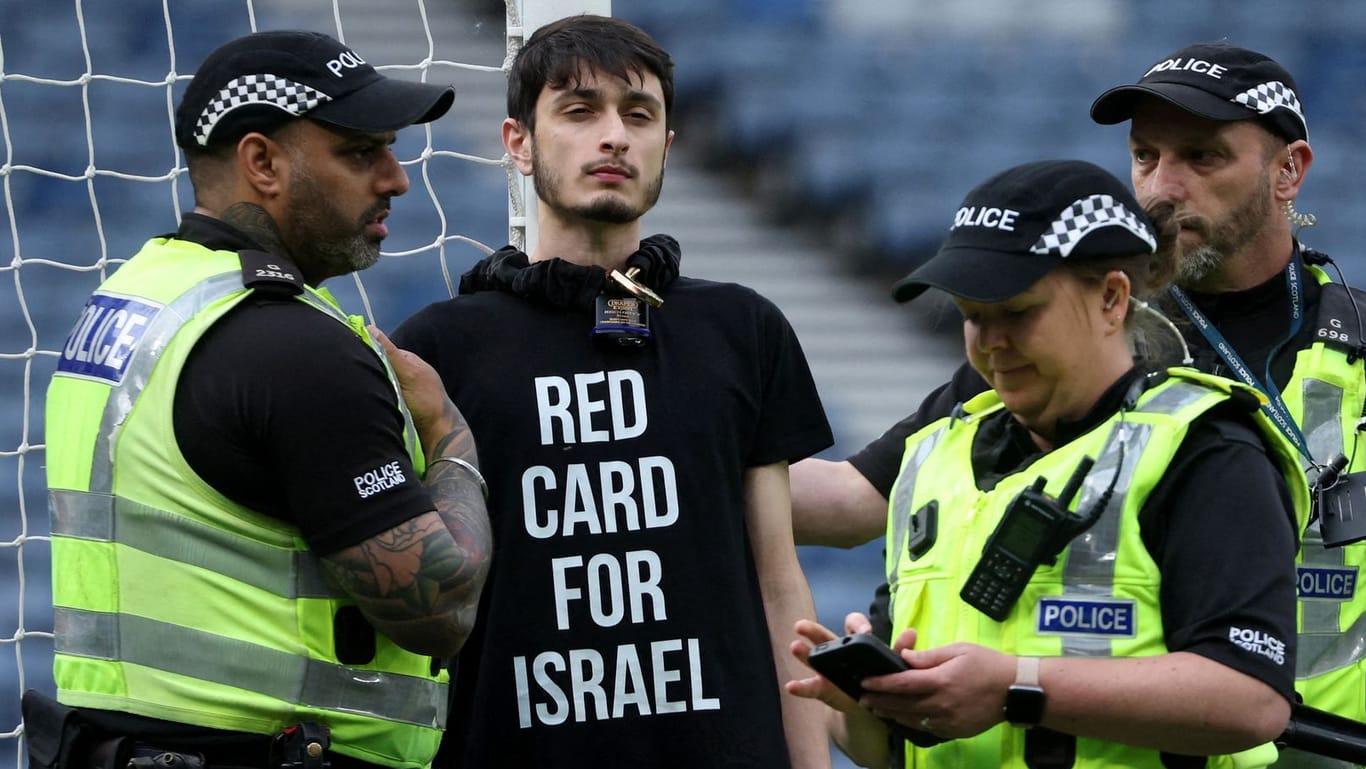 Protest: Ein Demonstrant hat sich an einen Pfosten im Hampden Park gekettet, Einsatzkräfte versuchen, ihn zu befreien.