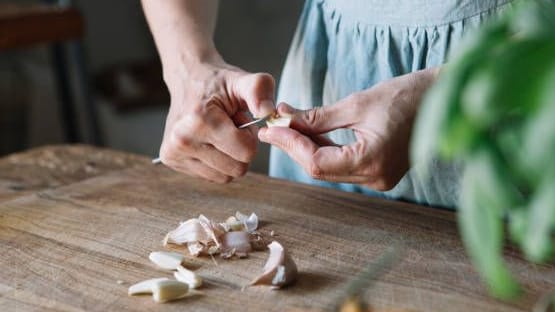 Knoblauchzehen schälen: Bei Körperkontakt mit rohem Knoblauch kann es bei Allergikern zu unerwünschten Reaktionen kommen.