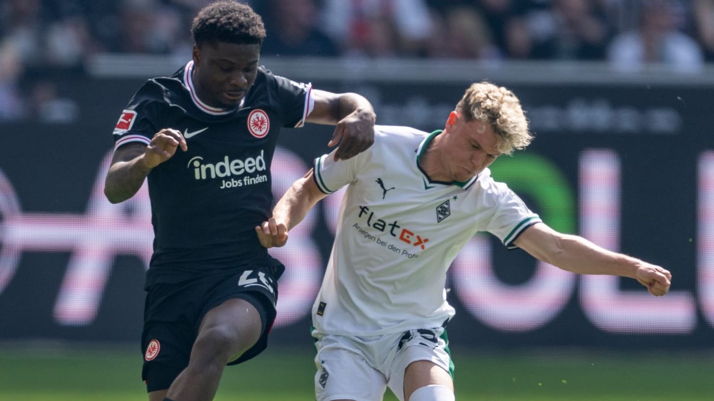 Frankfurts Eric Dina-Ebimbe (l) und Gladbachs Robin Hack kämpfen um den Ball.