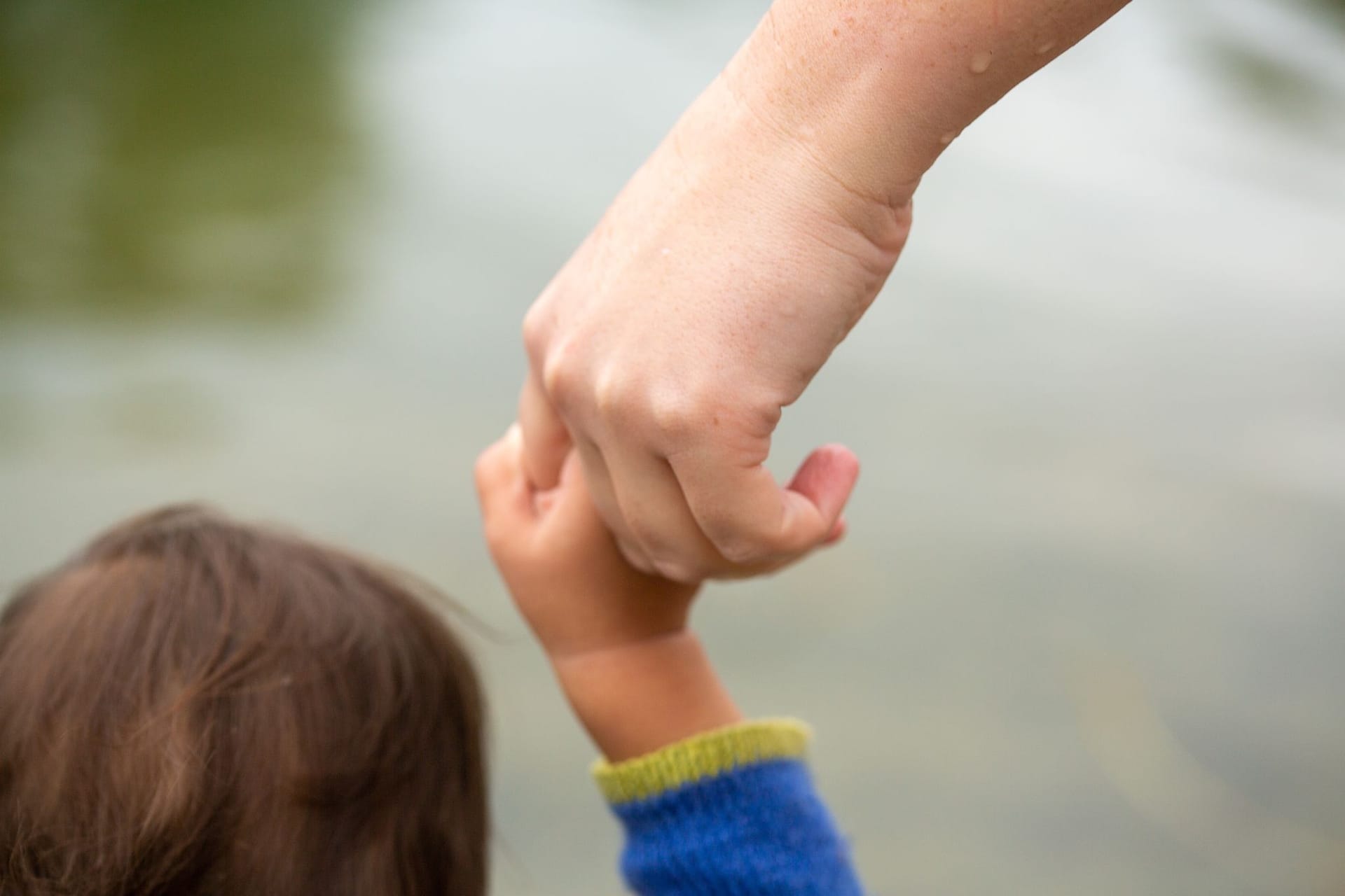 Mutter hält Kind an der Hand