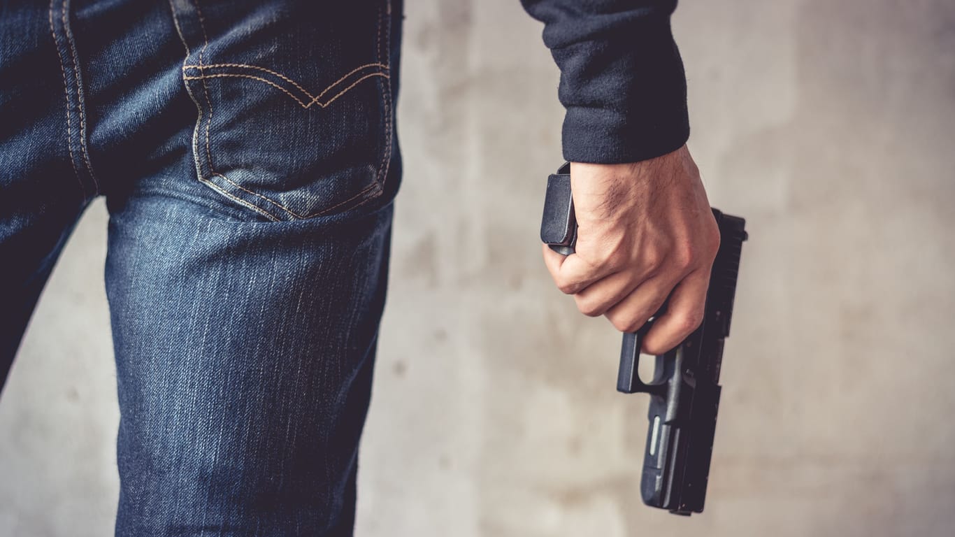 Ein Mann hält eine Waffe (Symbolbild): Ein 23-Jähriger hat in Kreuzberg einen bewaffneten Raubüberfall begangen.
