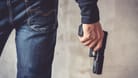 Ein Mann hält eine Waffe (Symbolbild): Ein 23-Jähriger hat in Kreuzberg einen bewaffneten Raubüberfall begangen.