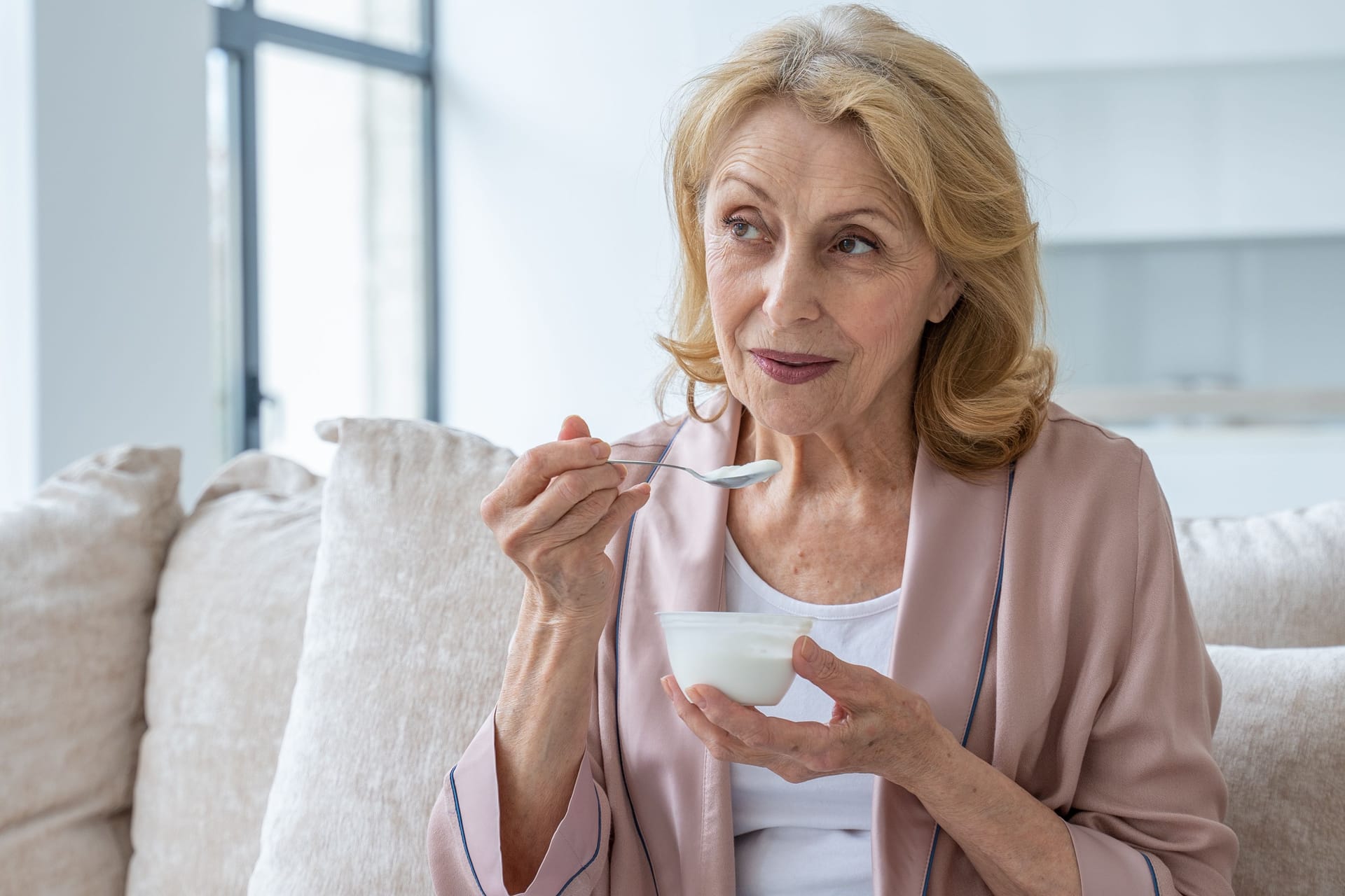 Eine Frau isst einen Joghurt.