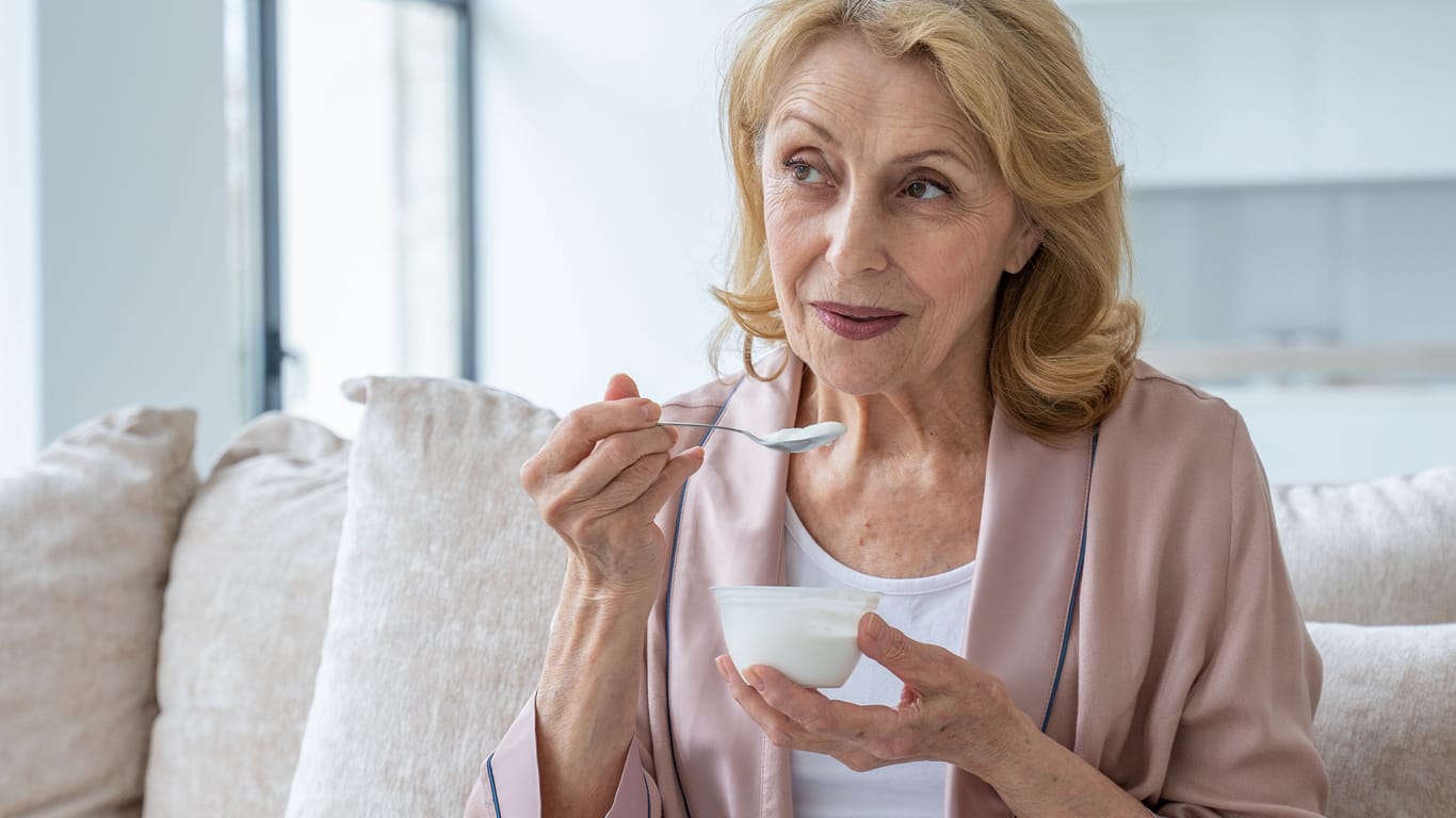 Eine Frau isst einen Joghurt.